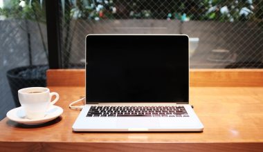 laptop computer beside coffee mug